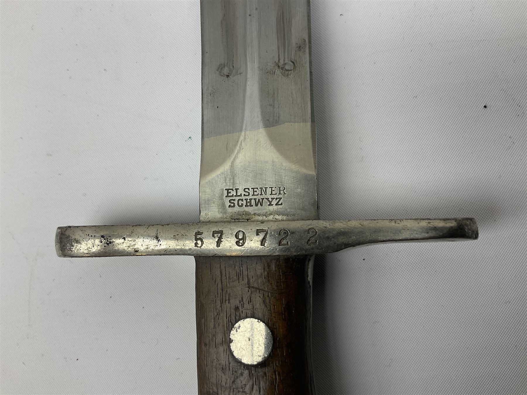 British Enfield 1907 model SMLE bayonet, with 43cm fullered steel blade and metal mounted leather scabbard L58cm overall; and Schmidt-Rubin Model 1918 bayonet the 30cm steel blade marked Elsener Schwyz No.579722; in steel scabbard with leather frog marked G. Bertolini Sellaio Vira/G.Tic 79 L45cm overall (2)