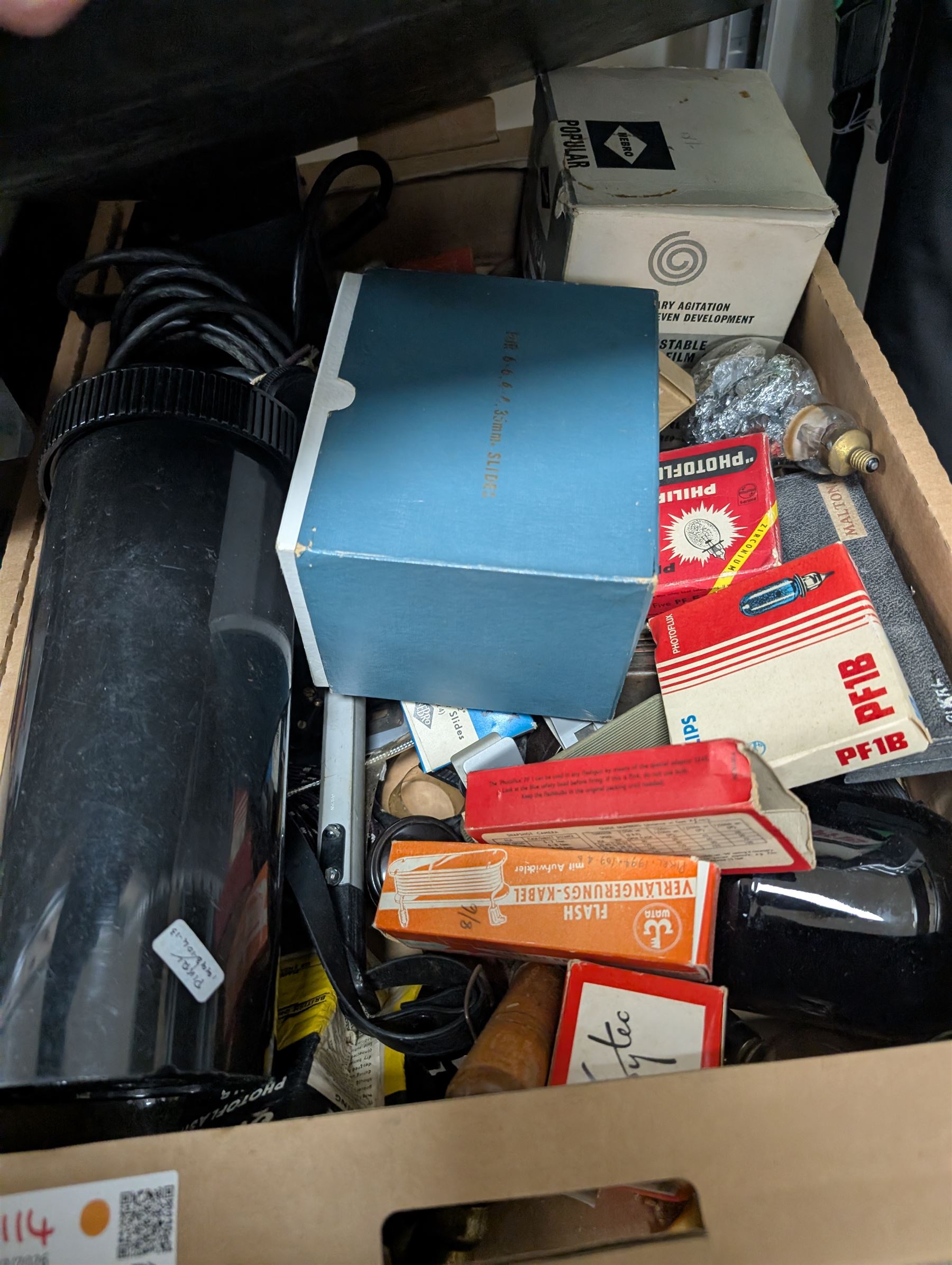 Collection of photography and photograph development accessories, including bulbs, development tanks, trays, projector lenses, etc