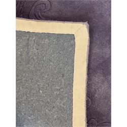 Chinese wool rug, purple ground with tonal floral and foliate pattern, central medallion of stylised flowers, the corners with large rosettes, framed by broad border of scrolling floral and leafy motifs 