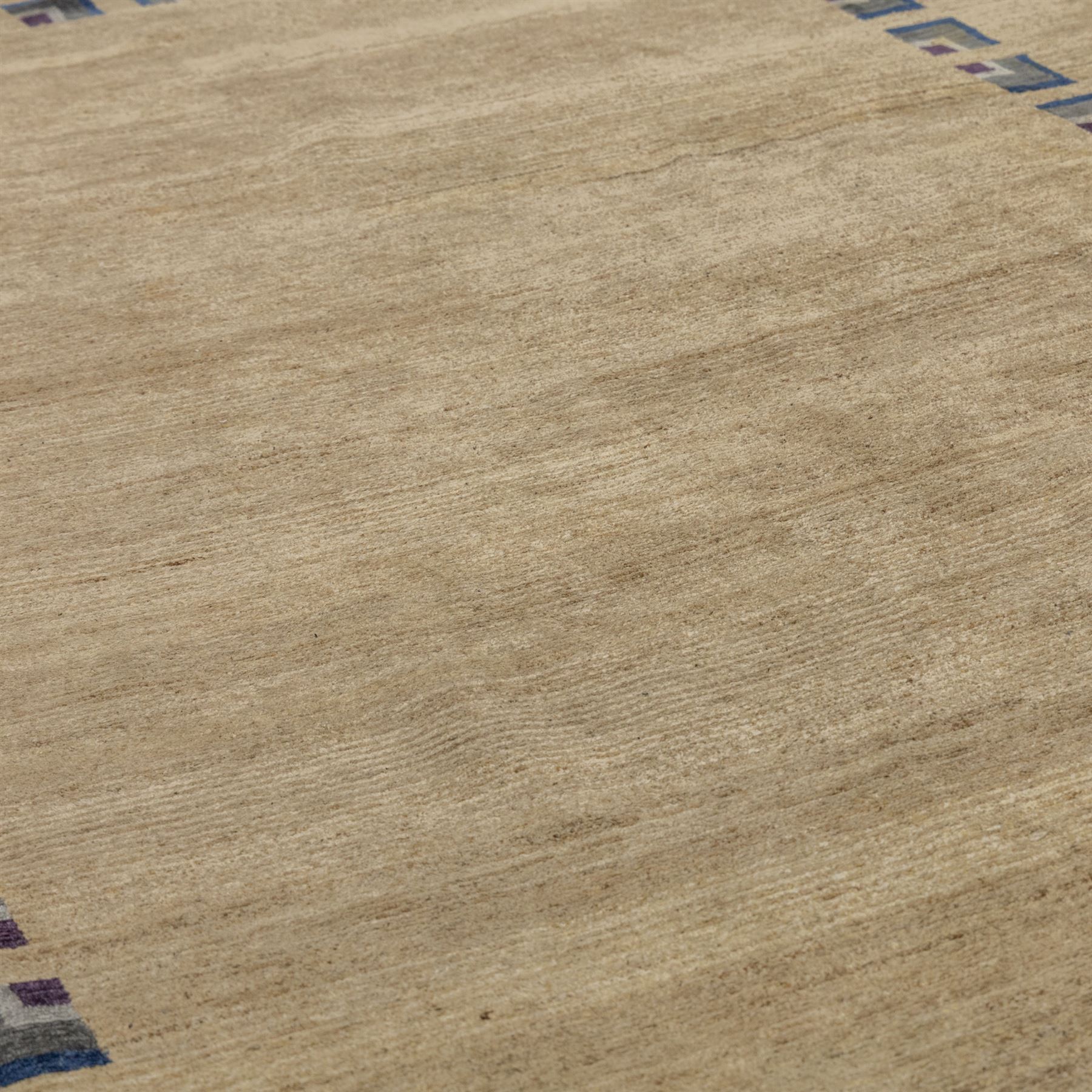 Rugs by Design - ‘Silk Stone’ Nepalese thick pile wool rug, with plain textured camel ground and geometric border detail in blue, grey and dark tones to all four sides