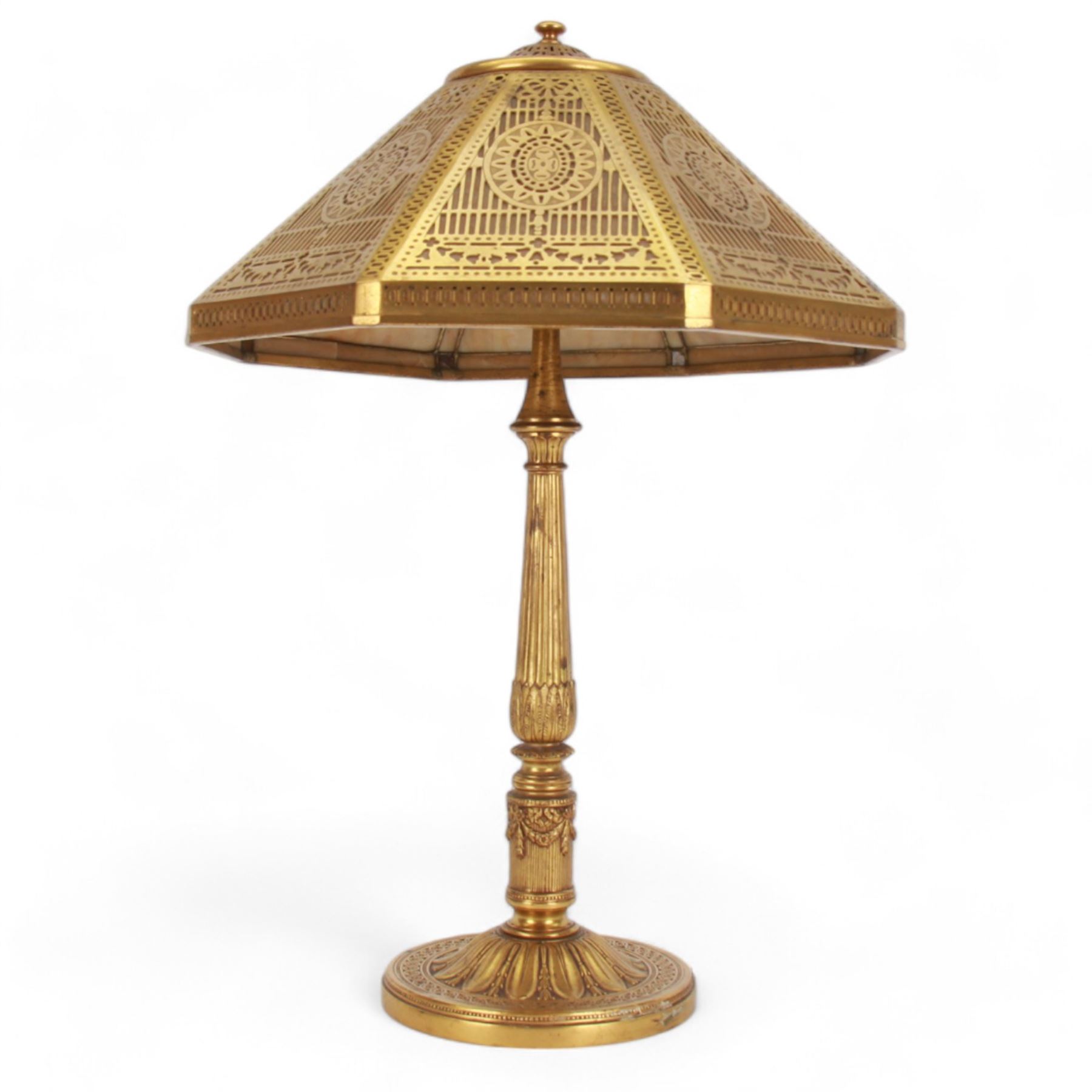 In the manner of Tiffany & Co, early 20th century gilt bronze Adam pattern table lamp, circa 1910, the circular spreading base decorated with flower heads and beaded bands, stiff leaves and husks, leading to a reeded column detailed with stiff leaves and swags, supporting a pierced octagonal shade, with original fittings, stamped beneath Tiffany Studios New York 539, overall H44.5cm


