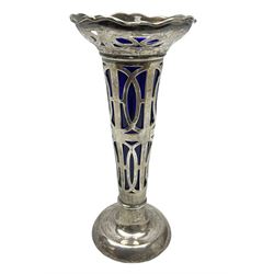 20th century silver specimen vase, of pierced trumpet form with flared rim, filled base, and blue glass liner, hallmarked Birmingham 