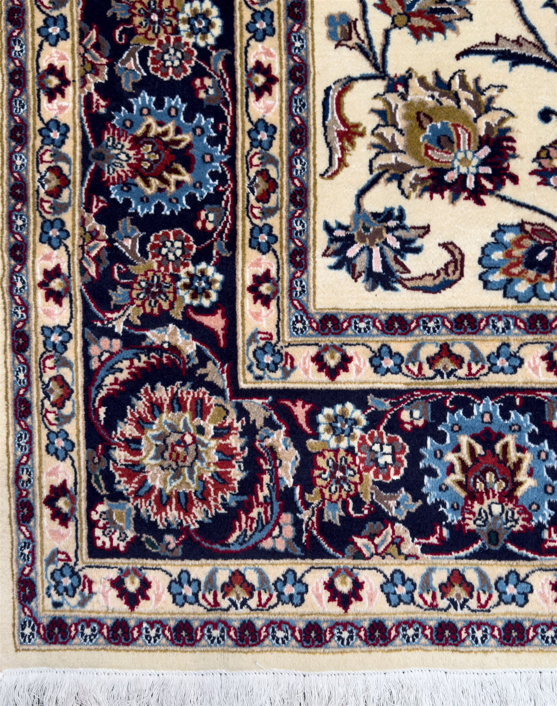 Northeastern Persian Meshed hand-knotted rug, ivory ground with an overall design of scrolling vines, palmettes, and rosettes in an indigo palette, soft blues, and madder, framed by a deep indigo border of lotus palmettes and flowerheads between multiple guard borders, 300cm x 202cm