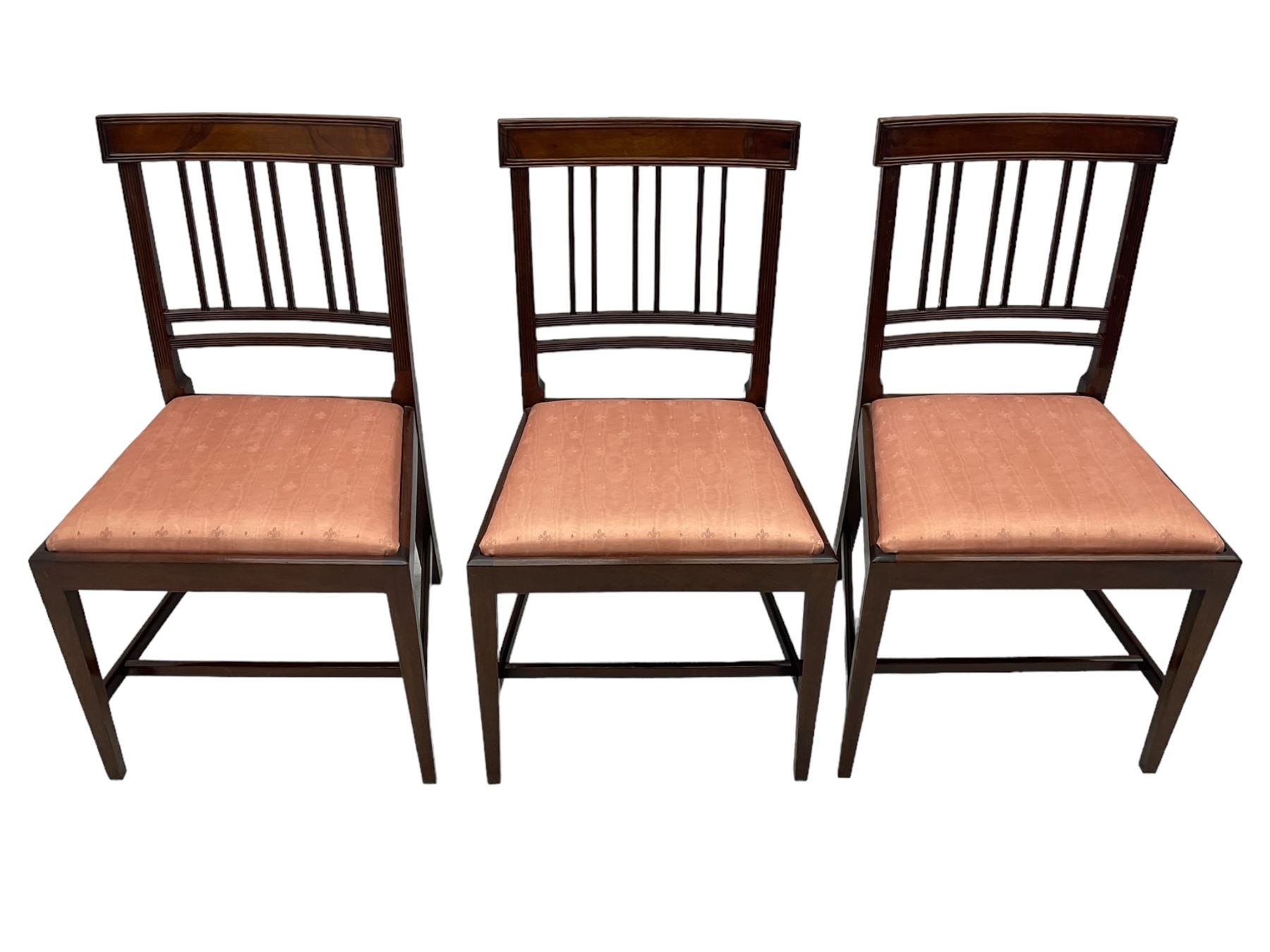 Early 20th century Regency design mahogany tilt-top table, circular top with edge banding, supported by a central turned pedestal with four reeded sabre supports terminating in castors; six chairs with pink upholstered drop in seats (7)