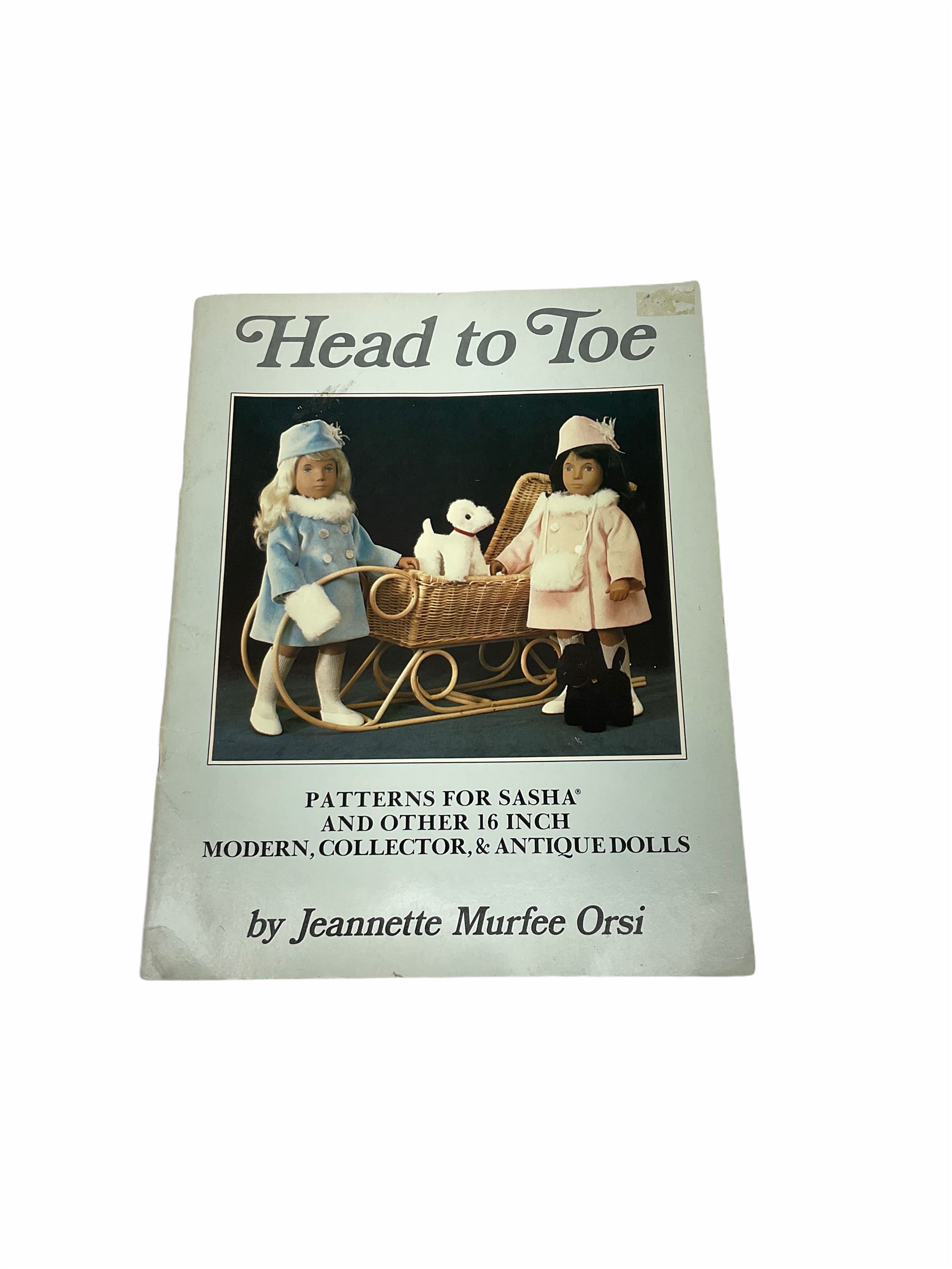 Heidi Ott doll in tartan dress, navy floral dress with white lace and ribbon detailing, striped blue and white dress and a 'Head to Toe' book