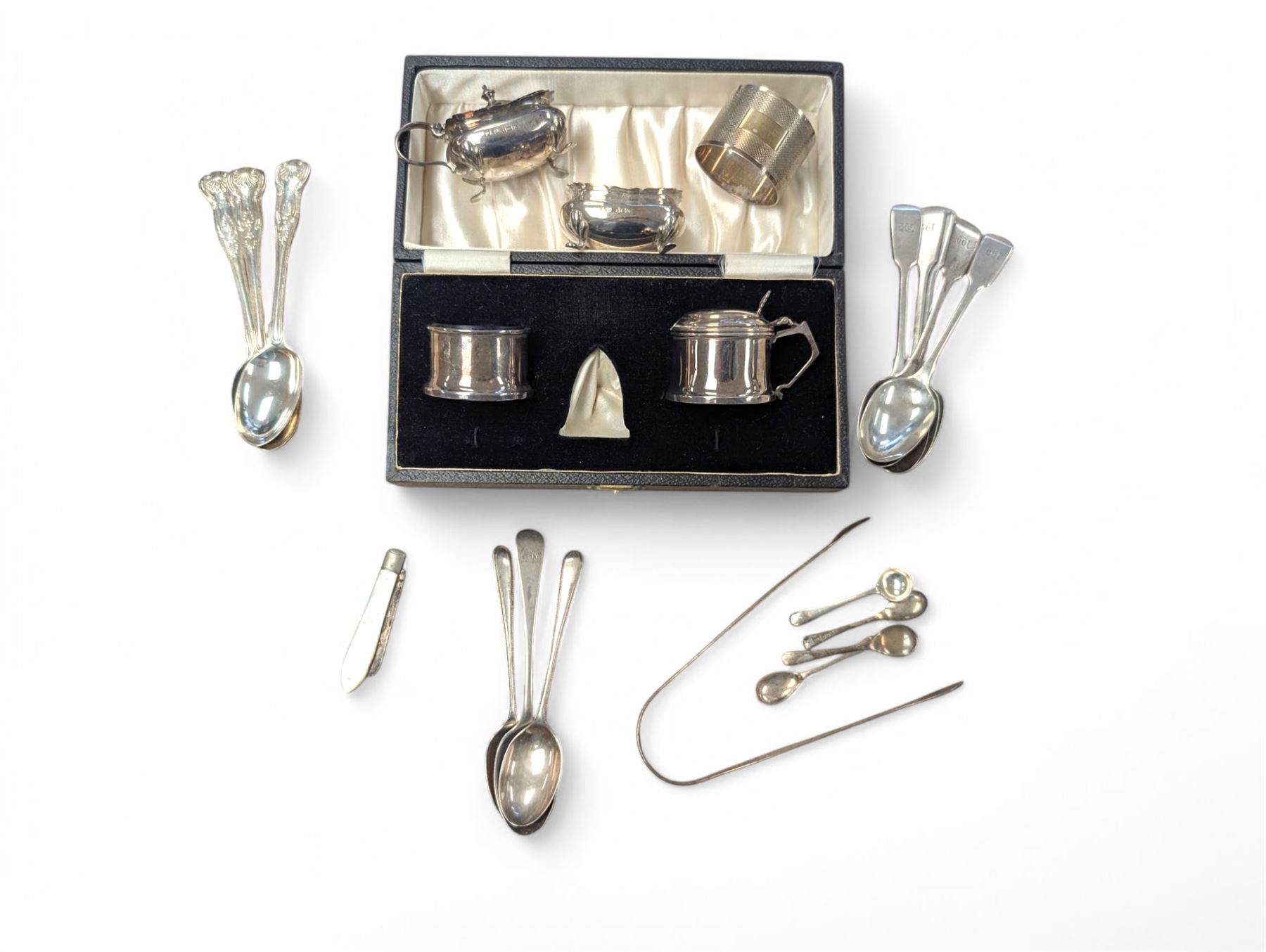 Group of silver, comprising mustard pots, open salts, napkin ring, spoons, sugar tongs and fruit knife, all stamped or hallmarked 