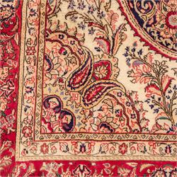 West Central Persian Sarouk hand-knotted carpet, ivory field with central ornate medallion and scrolling vines and palmettes, surrounded by large stylized boteh motifs and flowering foliage, enclosed by a madder-red border of palmettes and floral vine ornament between multiple guard stripes, cotton fringe ends 