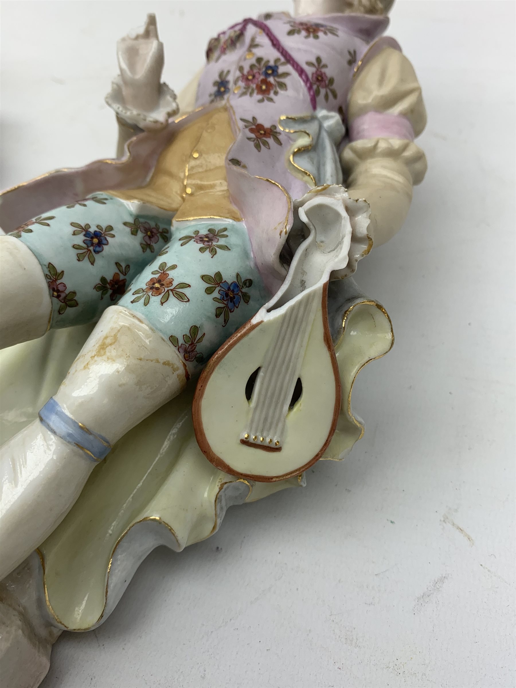 A pair of Continental porcelain figurines, the first modelled as a