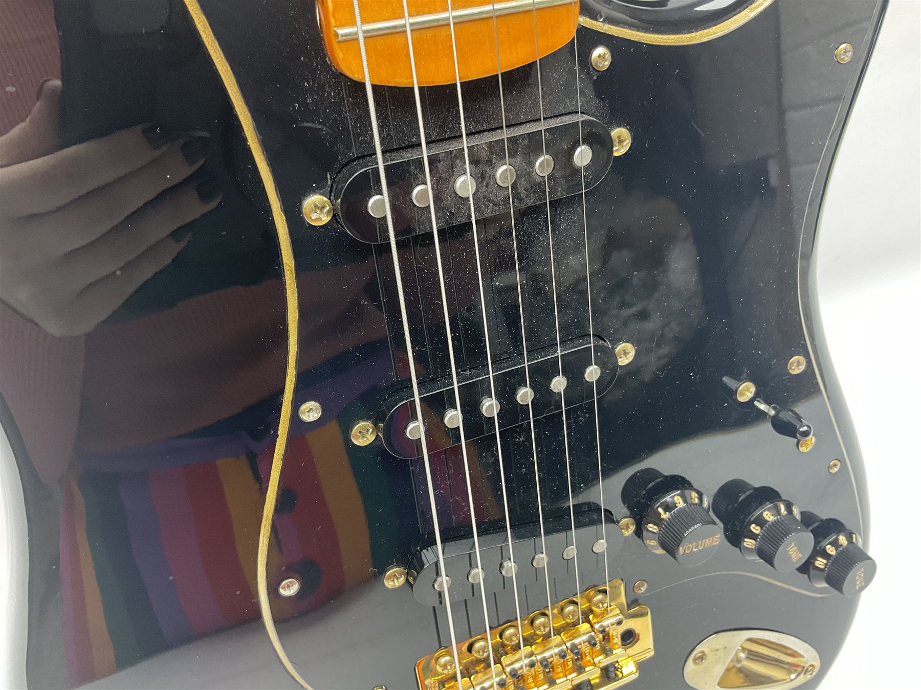 Copy of a Fender Stratocaster electric guitar in black with Wilkinson bridge, lock-in tuners, synchronised tremolo and various patent numbers; L99cm; in hard carrying case with strap and digital tuner