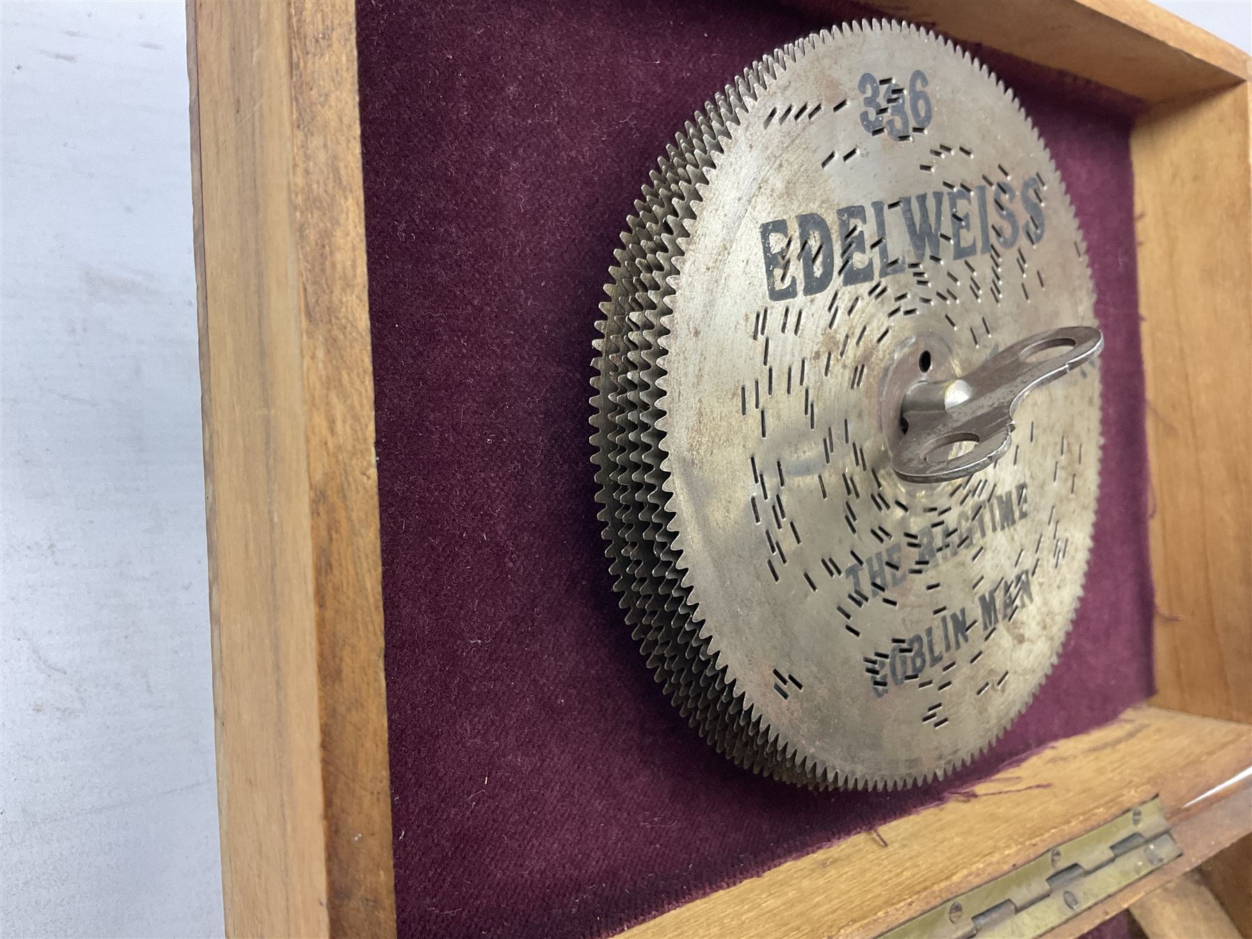 Victorian rectangular disc music box, the hinged lid with printed decoration of a young girl lifting to reveal a brass plate with single comb movement, with six discs, housed in pine case
