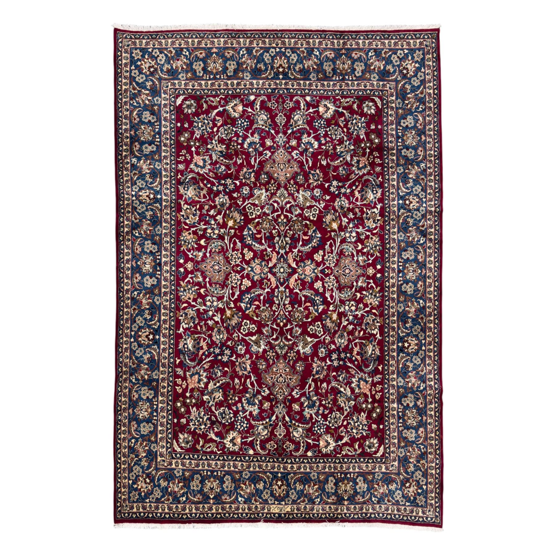 Central Persian Yazd hand-knotted rug, madder red field with scrolling vines, palmettes, and rosettes around a cusped lozenge medallion within a blue ground border of palmettes and flowerheads, 366cm x 250cm