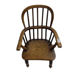 Childs Windsor elm and ash armchair, the double hooped and spindle back over saddle seat, raised on ring turned supports united by H-stretcher