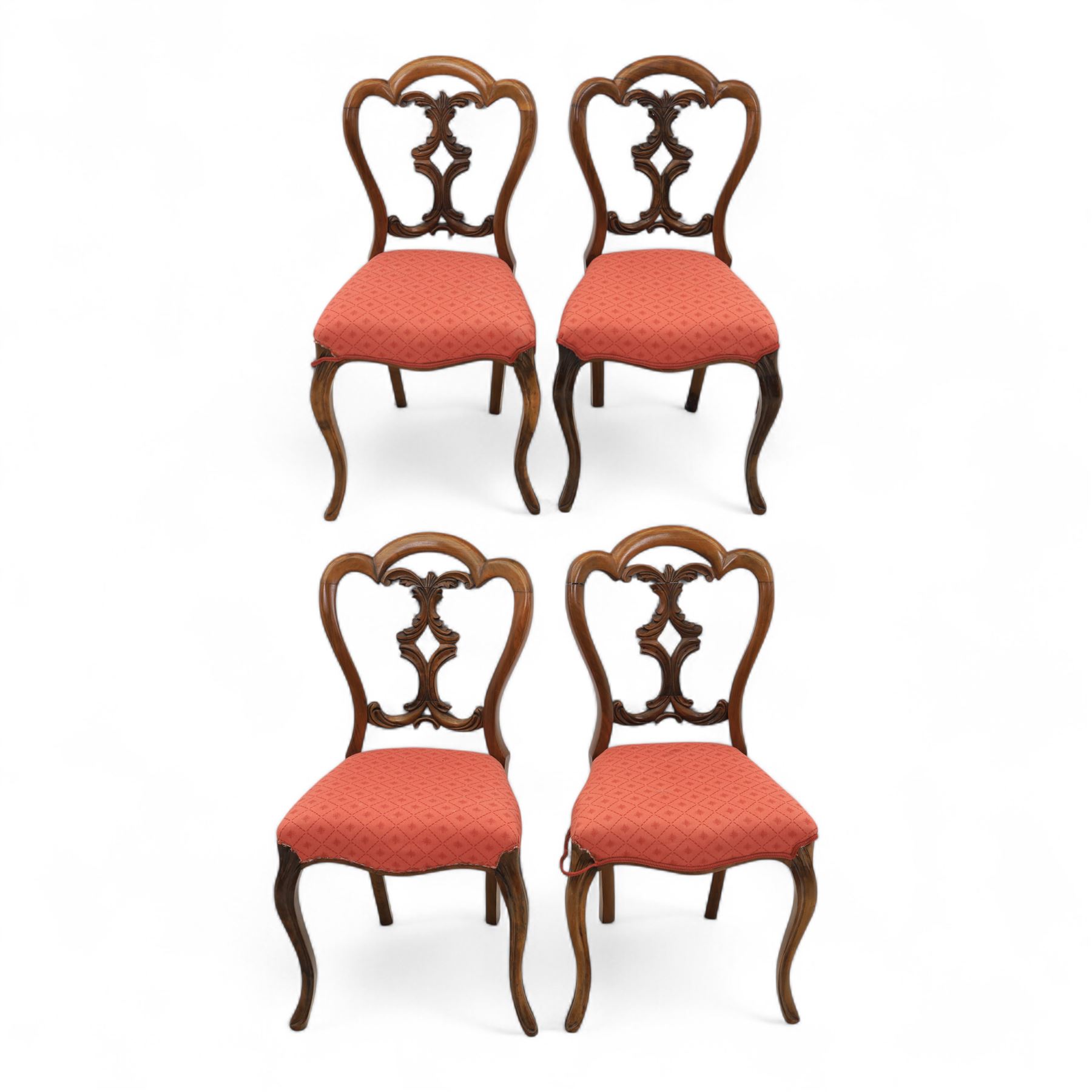 Set of four Victorian walnut balloon back chairs, with a carved and pierced back splat with foliate scrolls, serpentine seat upholstered in a diamond pattern fabric, raised on cabriole legs 