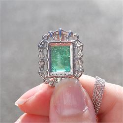 Platinum Colombian emerald and diamond pendant necklace, single octagonal cut emerald of 7.38 carat, surrounded by round cut diamonds in a fancy milgrain pierced design setting, stamped Pt 950, on a trace link chain necklace, total diamond weight 1.14 carat, with GCS certificate