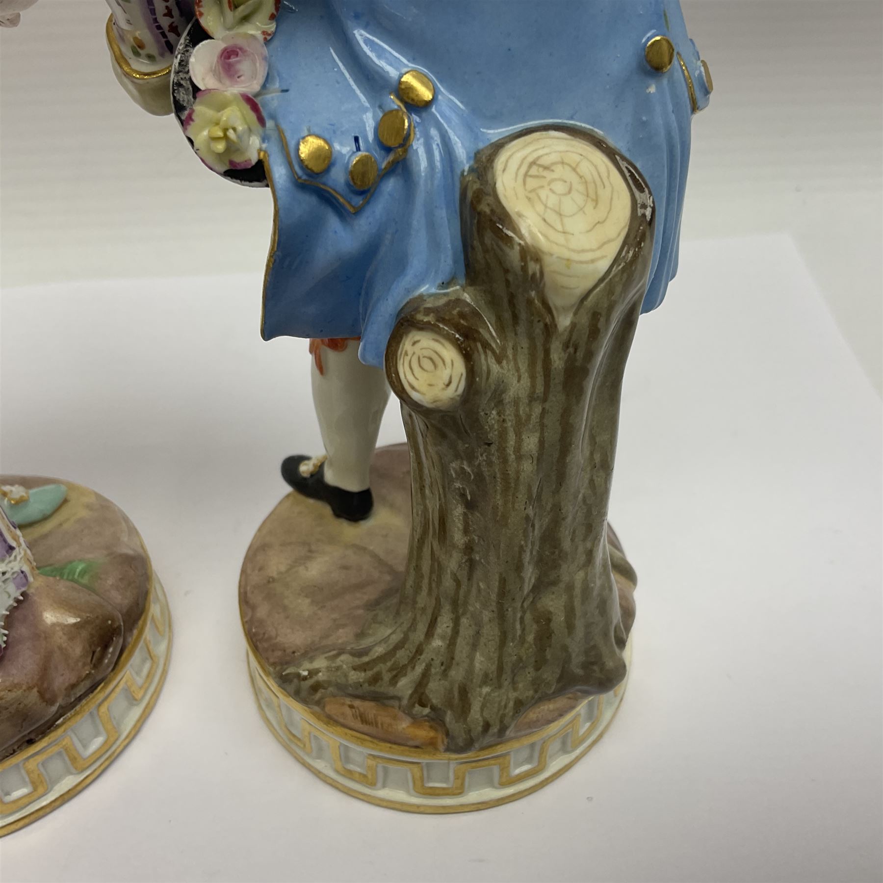 Pair of late 19th/early 20th Century Meissen figures, modelled as flower sellers, after the original by Michel Victor Acier, she holding basket of flowers, he holding flowers in his hat, each with underglaze cross swords mark beneath, tallest H16.5cm