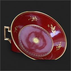 Late 19th century Vienna style coffee can and saucer, the cup with oval panel containing hand painted portrait of a gentleman, within a gilt foliate detailed surround, and upon a burgundy ground, the saucer with gilt band and sprigs upon a burgundy ground, with spurious shield mark beneath, cup H5cm saucer D12cm