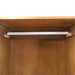 Edwardian Neoclassical figured ash and inlaid double combination wardrobe, the left section with mirrored door enclosing a hanging rail, the right section with cupboard door above four graduated drawers with glass knobs, raised on castors