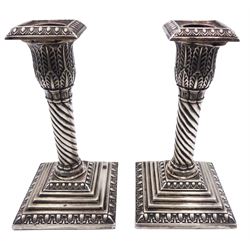 Pair of Edwardian silver candlesticks, each with acanthus detailed capital and removable beaded square nozzle, upon a twisted column and filled square stepped base, hallmarked Walker & Hall, Chester 1907, H14.5cm