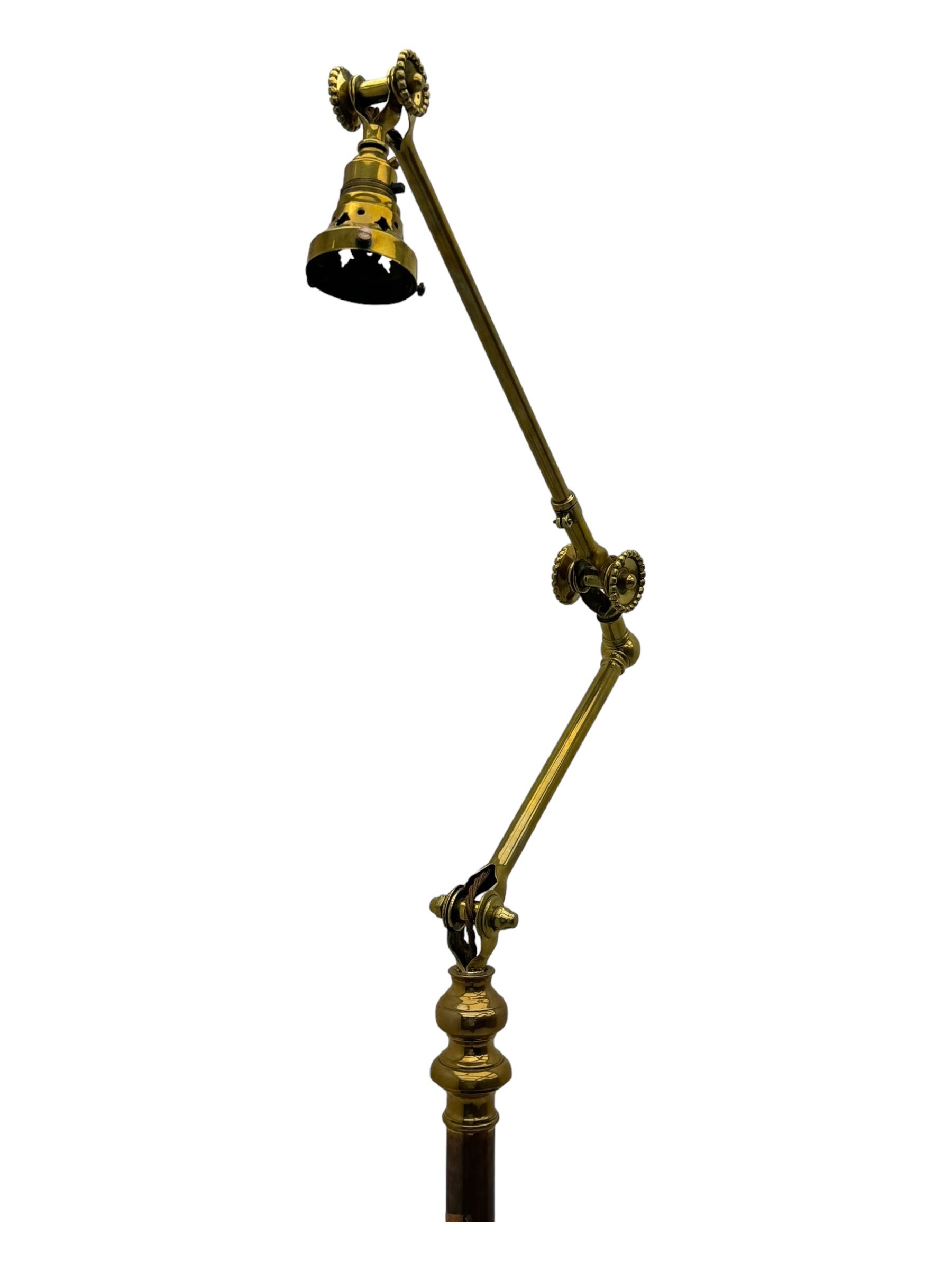 Early 20th century brass adjustable floor lamp, Royal Doulton decorative ceramic base embellished with raised floral and scroll patterns, stamped, brass column and adjustable arms terminating in brass bulb holder