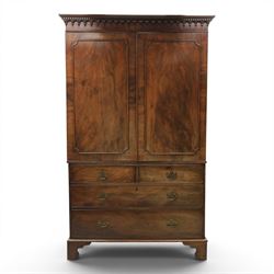George III mahogany linen press, projecting dentil cornice, moulded doors enclosing a shelved interior, above a lower section with two short over three long drawers, raised on bracket feet 