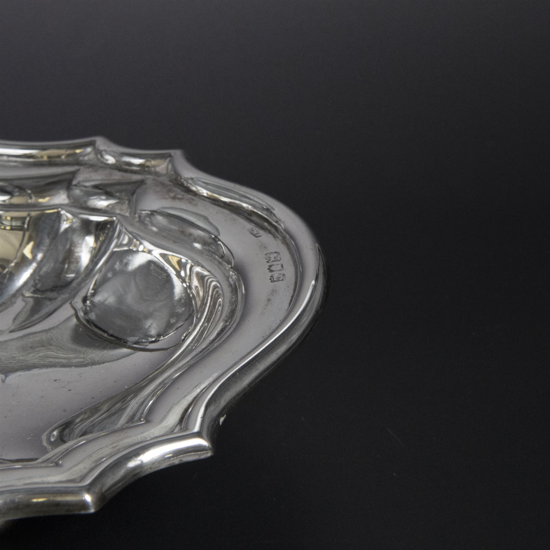 Early 20th century silver swing handled basket, of oval form with shaped rim and upon four bun feet, hallmarked C W Fletcher & Son Ltd, London 1918