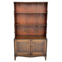 George III mahogany waterfall bookcase on cupboard, three raised shelves over double cupboard, enclosed by two panelled doors, fitted with brass carrying handles, on bracket feet