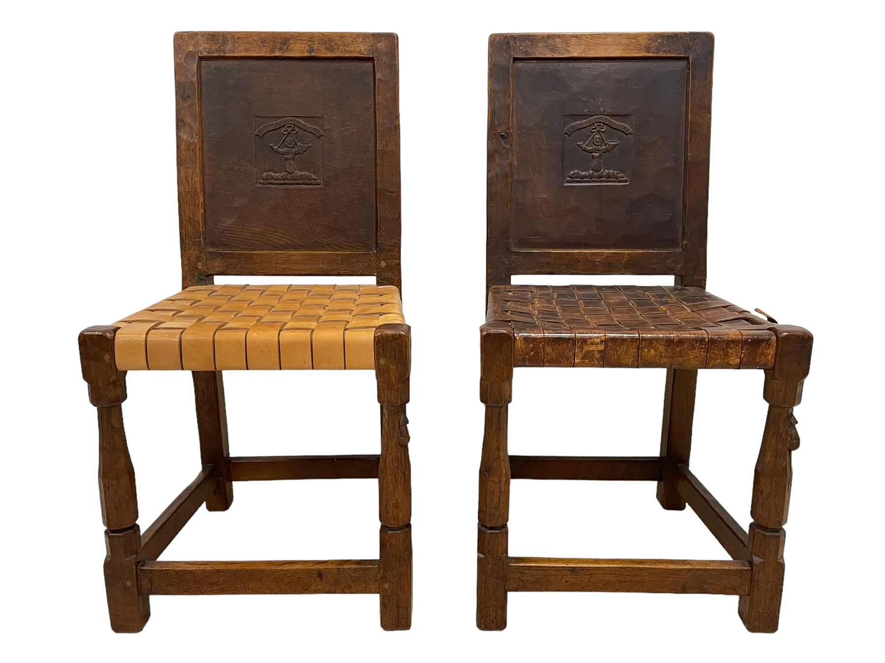 Mouseman - circa. 1930s set of six (4+2) oak dining chairs, panelled back carved with the Bagshawe family crest, the moto 'Forma Flos Fama Flatus' over an arm grasping a bugle-horn with ribbon tie and Yorkshire rose motif, adzed frame, leather lattice strap seat, on octagonal supports united by stretchers, two carvers and four side chairs, each carved with mouse signature, by Robert Thompson of Kilburn 

Provenance: Owned since manufacture by the Bagshawe family, descendants of the Staithes Group Artist Joseph Richard Bagshawe RBA (1870-1909).