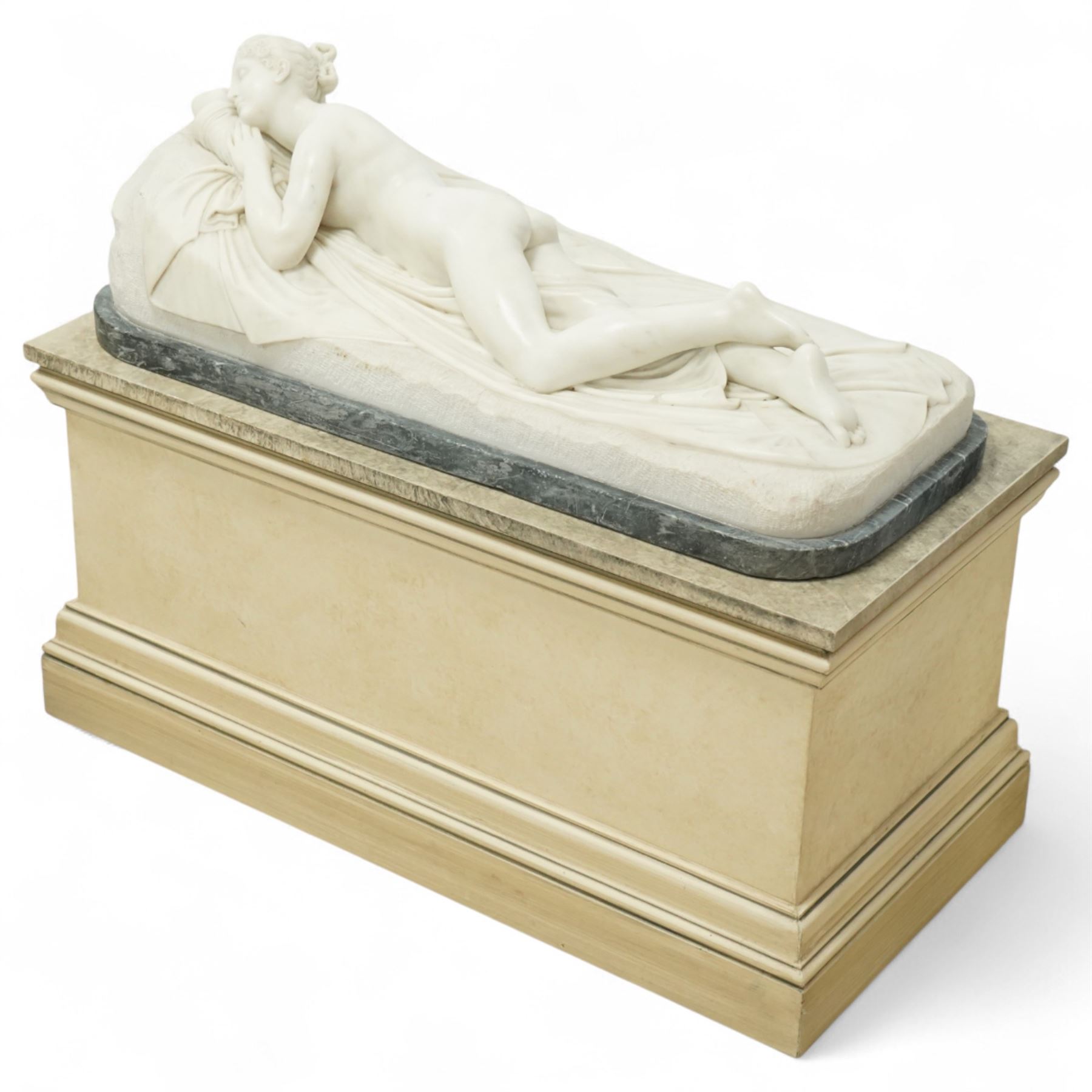After Antonio Canova (Italian 1757-1822): 'Sleeping Venus', an Italian carved white marble figure of a reclining nude, the serene figure depicted lying on her side, her head resting on a cushion and one knee gently raised, a loosely draped sheet partially covering her lower body, on a rectangular base with rough-hewn surround, raised on a marble plinth over a sarcophagus style pedestal, circa 1900

Provenance: Kirkham Hall

Notes: A late-19th-century homage to Canova’s neoclassical models, reflecting the Grand Tour taste for idealised classical beauty and the refined finish characteristic of Italian workshop marbles of the period