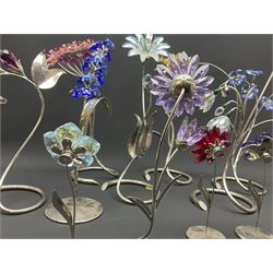 Eleven Swarovski Crystal flowers, to include violet, sunflower, delphinium, forget-me-not and lily-of-the-valley, each on stylised metal stems, tallest H23cm