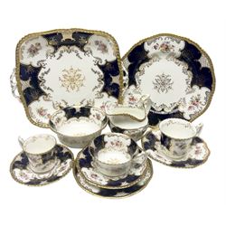 Coalport cobalt blue batwing pattern tea wares, decorated with finely enamelled floral sprays within gilt reserves, comprising teacup trio, coffee can and saucer and other cup and saucer, twin handled cake plate, milk jug and open sucrier, and circular plate retailed by T. Goode & Co London, pattern no Y2665,  all with green Coalport AD 1750 marks beneath, largest W26cm (11)