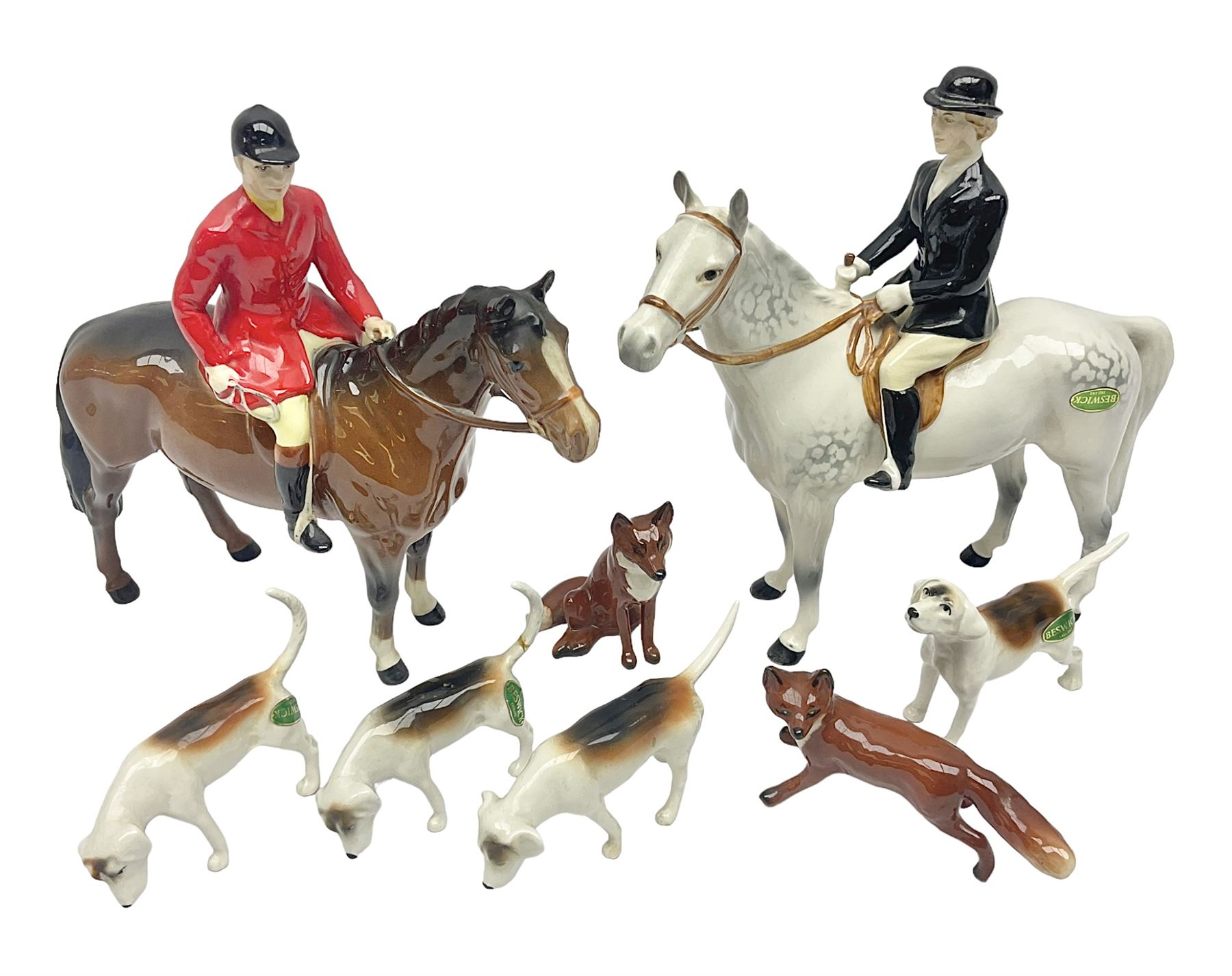 Beswick hunting group, comprising huntswoman on dappled grey horse no 1730, huntsman on bay horse no 1501, two fox figures no 1440 and 1748, and four fox hounds, all with printed marks beneath (8)