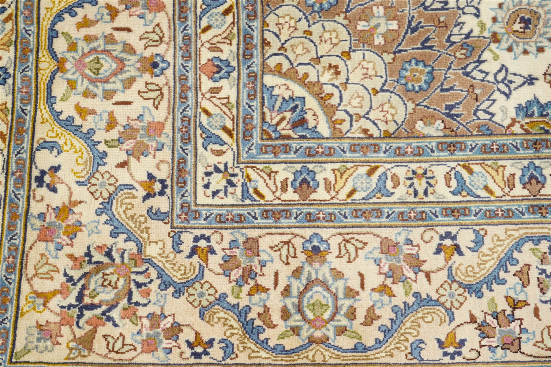 Central Persian Nain hand-knotted carpet, ivory field with central radiating medallion with pendants, issuing an all-over design of scrolling vines, palmettes, and floral sprays within confirming spandrels, framed a complimentary foliate border flanked by multiple guard stripes, with cotton fringe ends 