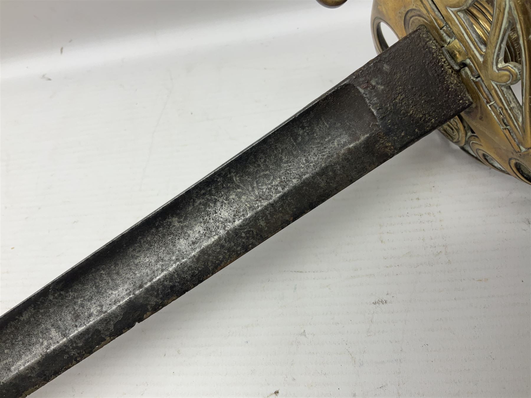 Victorian 1845 pattern infantry officer's sword the 82cm sharpened fullered steel blade with traces of decoration, brass gothic hilt incorporating Victorian cypher, folding back guard, stepped pommel with acanthus leaf backstrap and wire-bound wooden grip with traces of original fish skin covering L96cm overall; together with a reproduction Scottish style basket hilted sword; both lacking scabbard (2)