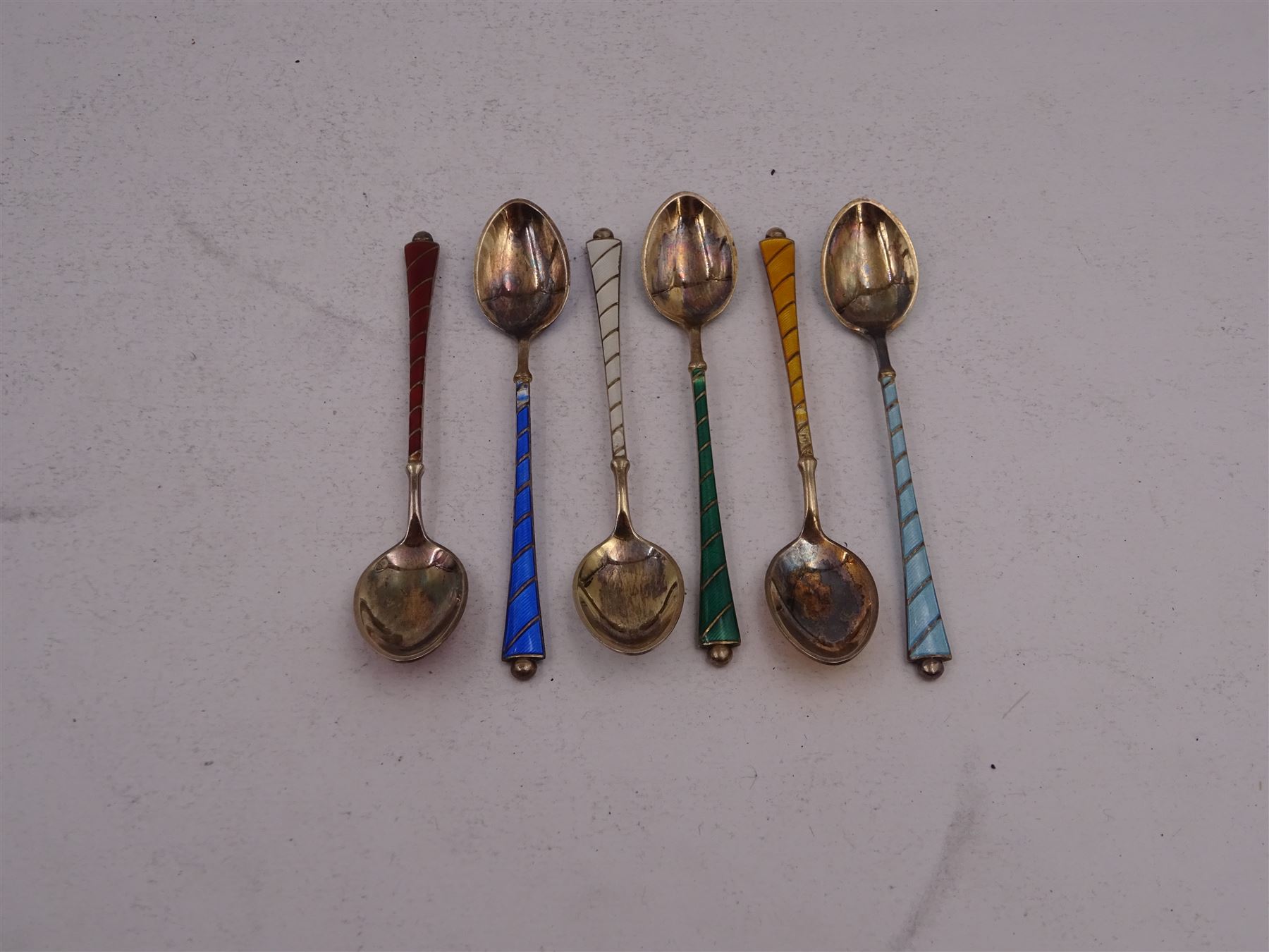 Set of six Danish silver gilt coloured guilloche enamel coffee spoons, each spoon with twist design enamel handle and ball finial, stamped Ela Denmark Sterling, in case