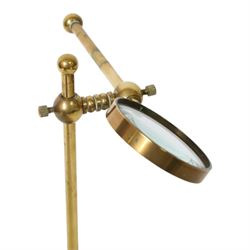 Early 20th century lacquered brass table top adjustable magnifying glass, with pivoting lens upon a circular weighted base, H26cm