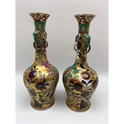 Pair of early 19th century Miles Mason vases, the baluster bodies with tall slender necks supporting twin stylised trunk handles with rings, decorated with Chinese dragons, butterflies, and blossoming flowers against a gilt ground, with spurious Chinese marks beneath in iron red, H27.5cm