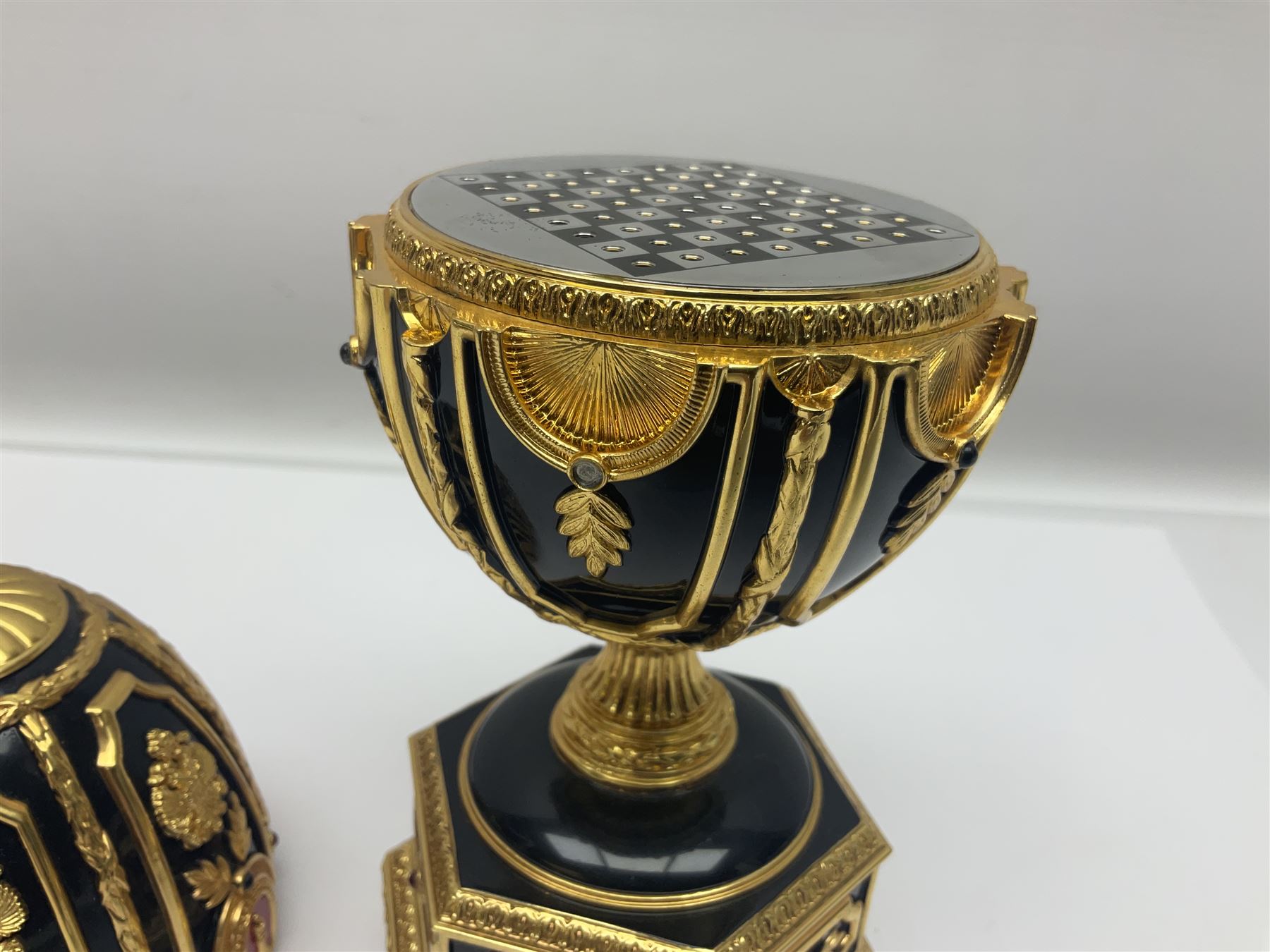 Franklin Mint House of Faberge; The Imperial Jeweled Egg Chess set, the egg opening to reveal a chess board, with a draw to the hexagonal base holding the miniature chess pieces, H23cm 