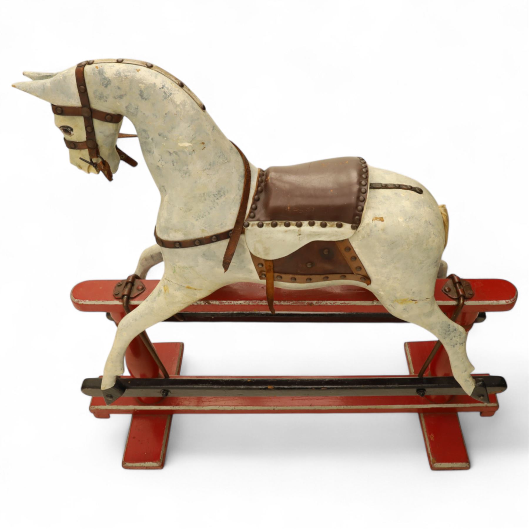 20th century carved and painted rocking horse, with original dappled paint finish, studded leather saddle and reins, on later red and black swing frame