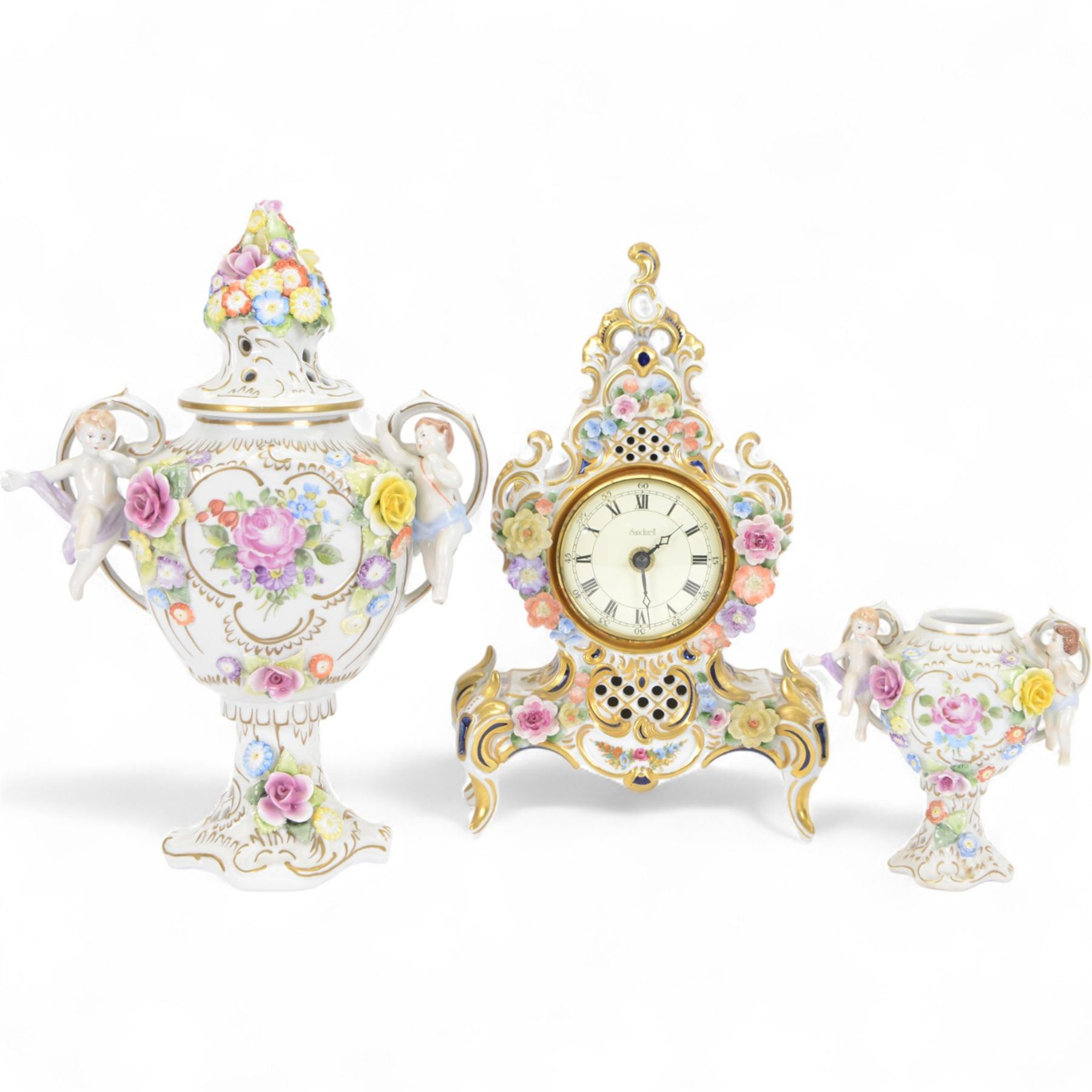 Reine Handarbeit, German ceramic cased mantle clock with applied floral decoration, together with two vases, clock H31cm