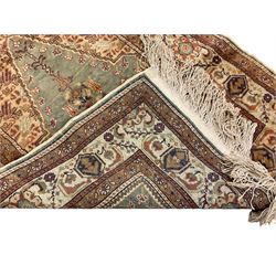 Persian ivory ground rug, central Mirab motif surrounded by floral decoration, guarded border with palmettes (131cm x 92cm); Persian design camel ground rug, central indigo Mirab motif, the guarded borders with scrolling flower heads (207cm x 128cm)