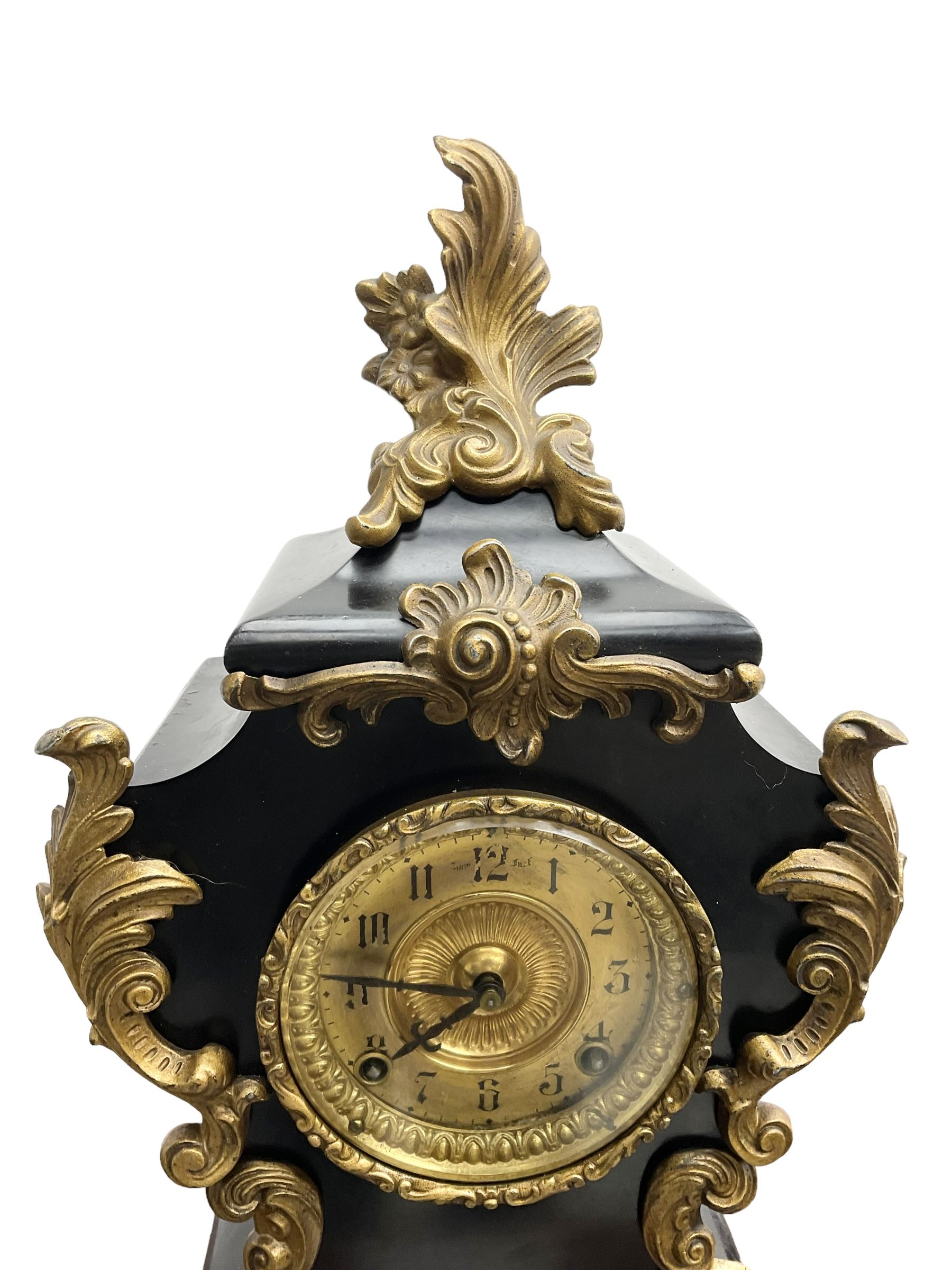 Ansonia - American late 19th century steel cased 8-day mantle clock in a Rococo case with decorative brass mounts, brass dial with Arabic numerals, steel hands and a repousse dial centre, twin train striking movement sounding the hours and half hours on a gong. with pendulum and key.