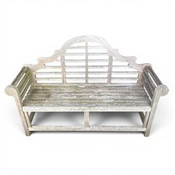 Lutyens design teak garden bench, shaped arched and slatted back over rolled arms and slatted seat, raised on square supports with box-stretcher