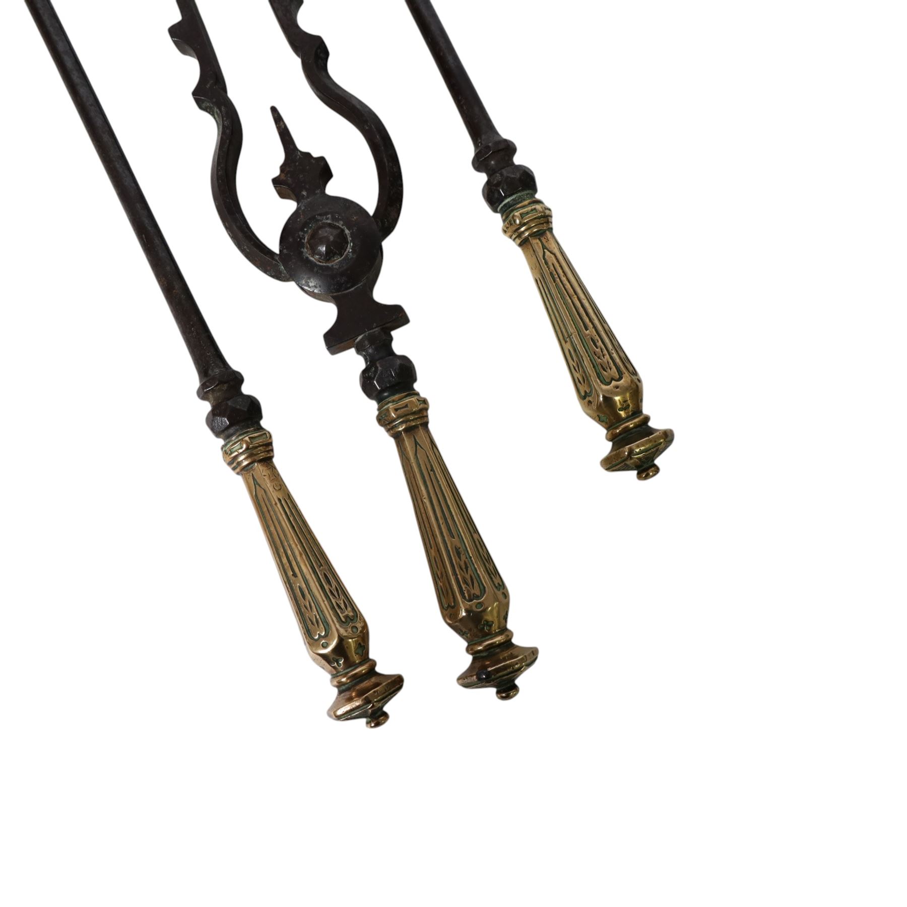 Set of three 19th century brass and steel fire irons, each with tapering and hexagonal capped handles, comprising poker, tongs and shovel with pierced detail, poker L84cm