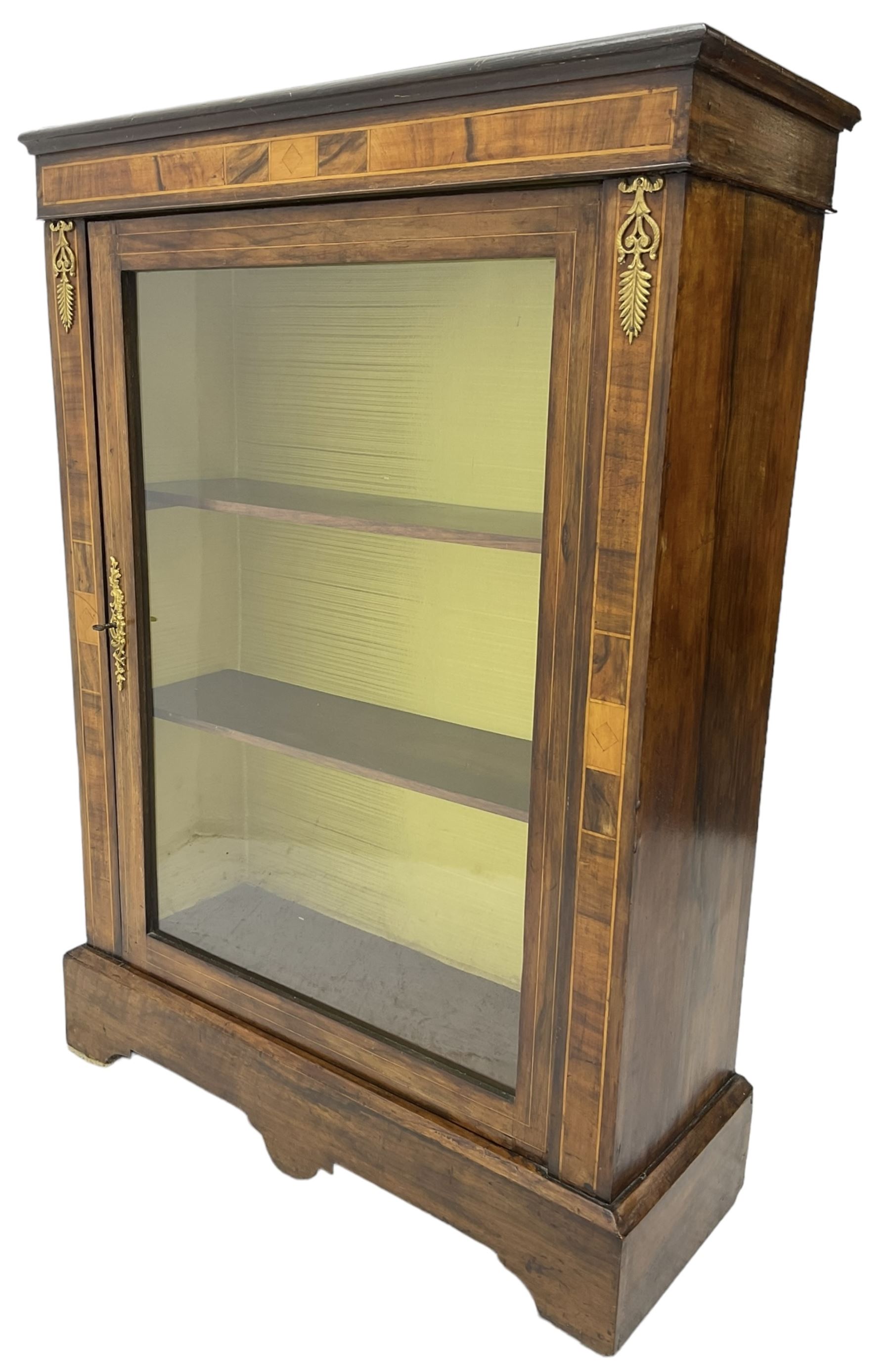 Victorian walnut pier cabinet, moulded rectangular top over inlaid frieze and uprights, enclosing by single glazed door, the interior fitted with two shelves, on shaped bracketed plinth base
