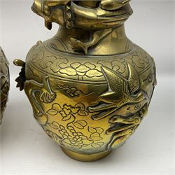 Pair of Chinese brass vases, of ovoid form with elongated neck and fluted rim, decorated in high relief with a dragon chasing a flaming pearl around the neck, the body with dragons, birds and buildings, with character marks beneath, H25cm