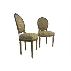 Pair 19th century French giltwood drawing room chairs, the oval back frame with acanthus leaf decorated ribbon twist carving, back and sprung seat upholstered in foliate patterned fabric, apron carved with guilloche decoration, raised on fluted supports