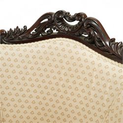 Victorian carved mahogany tub chair, upholstered in cream patterned fabric, with pierced foliate carved top rail, curved back and seat, serpentine seat rail, on cabriole front legs with brass castors