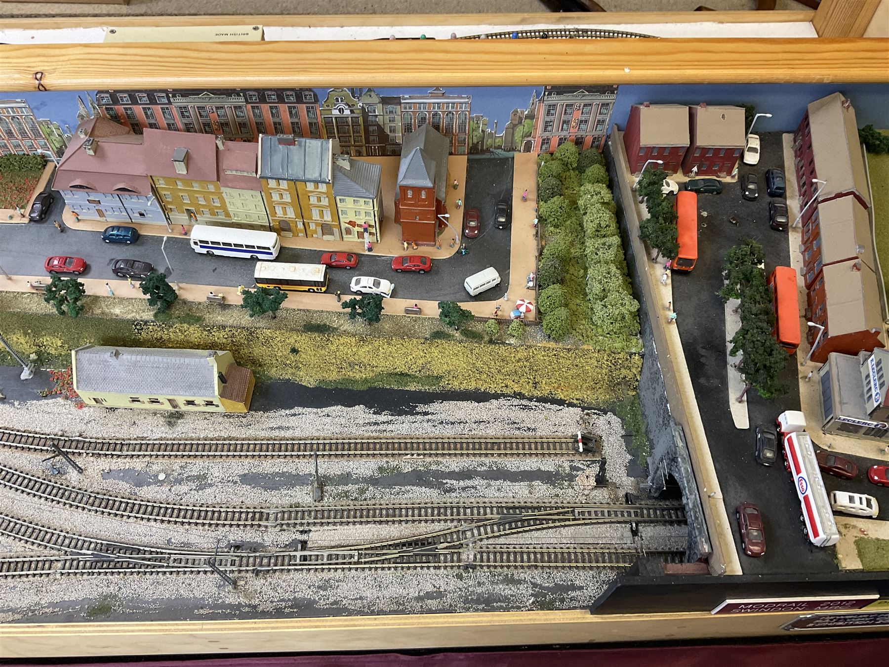 'Z' gauge continental scenic layout with folding legs, various loops of track and sidings with overhead cables, buildings including water tower, tunnels, roads with motor vehicles and figures, trees, haven with boats, backdrop diving wall hiding control units 150 x 50cm
