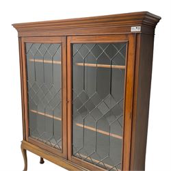 Early 20th century walnut display cabinet, projecting moulded cornice over two lead glazed doors, the interior fitted with three adjustable shelves, on cabriole supports