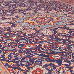 North West Persian carpet, the indigo field centred by a lobed medallion in pale blue and ochre with floral pendants, profusely decorated with scrolling foliage, palmettes and flowerheads, ivory floral spandrels, enclosed by a red ground palmette border and multiple floral guard bands